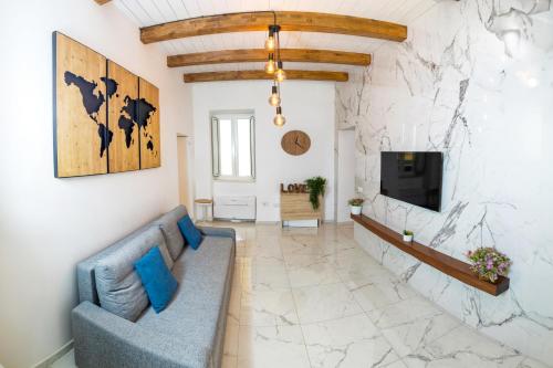 ein Wohnzimmer mit einem blauen Sofa und einer Steinmauer in der Unterkunft Paradise Luxury Apartment Salerno Center in Salerno