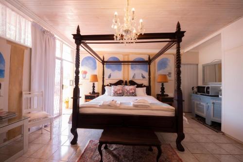1 dormitorio con cama con dosel y lámpara de araña en Nelheim en Vredenburg