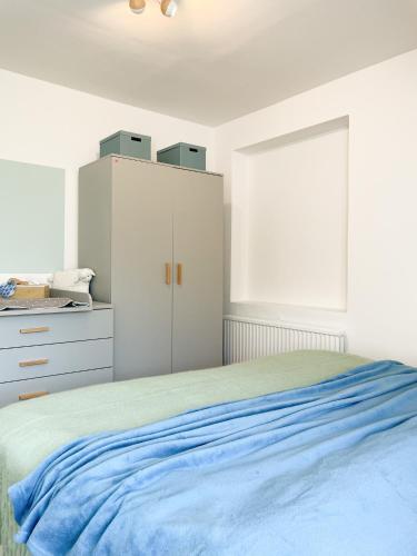 a bedroom with white cabinets and a blue bed at Ferienhof Bannick in Bistensee