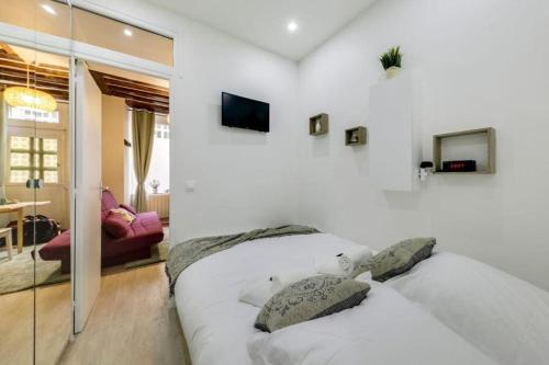 - 2 lits blancs dans une chambre avec un salon dans l'établissement Tiny boutique Apt Central Mouffetard Area, à Paris