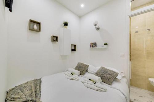 - une chambre blanche avec un lit et une salle de bains dans l'établissement Tiny boutique Apt Central Mouffetard Area, à Paris