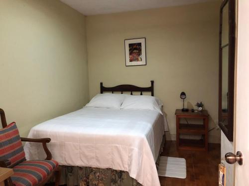 La TeneríaにあるPosada Rosa Balvinaのベッドルーム(白いベッド1台、椅子付)