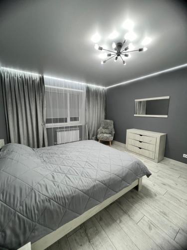 um quarto com uma cama e uma ventoinha de tecto em Яркая студия в новом доме em Oral