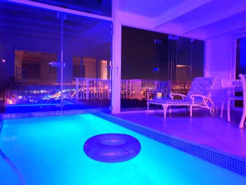 a swimming pool with a bench and a table at 'The Bolussi Beachhouse', sleeps 12 in 6 en-suite bedrooms with Indoor Pool in Gordonʼs Bay