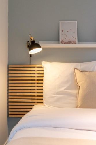 - une chambre avec un lit blanc et une lumière au-dessus dans l'établissement Tourcoing near the station, à Tourcoing