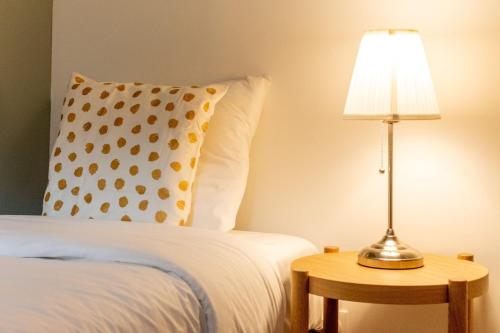 a bed with a pillow and a lamp on a table at Lille Centre - Nice ap. 4pers in Lille