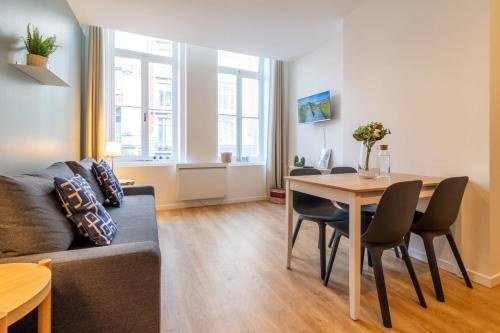 a living room with a couch and a table with chairs at Lille Centre - Nice ap. 4pers in Lille
