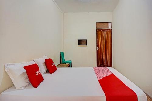 a bedroom with a bed with red and white pillows at OYO 93264 Penginapan Syari'ah Berlian in Takengon