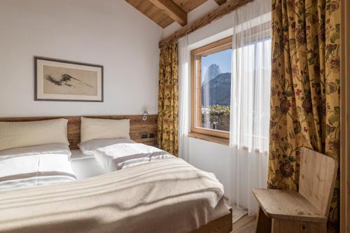 a bedroom with a bed and a window at Cësa Marmolada 1318 in Ortisei