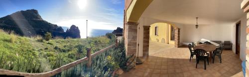 a house with a balcony with a view of the mountains at Il Sole ed Il Mare Tanca Piras in Nebida