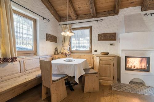奧爾蒂塞伊的住宿－Cësa Marmolada 1318，一间带桌子和壁炉的用餐室
