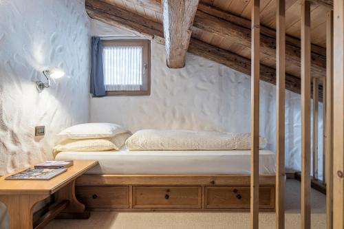 a bedroom with a bunk bed and a table at Cësa Marmolada 1318 in Ortisei
