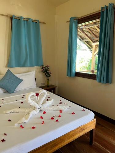 a bedroom with a bed with roses on it at Lunazul Guesthouse in San Vicente