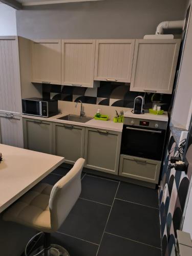 uma cozinha com armários brancos e um piso preto em PM 410 Via Delle Forze Armate Guest House em Milão
