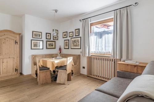 a living room with a table and a couch at Cësa Marmolada 1318 in Ortisei