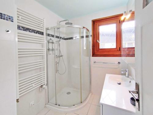 une salle de bain blanche avec une douche et un lavabo dans l'établissement Edelweiss 2 Apartment, à Chamonix-Mont-Blanc