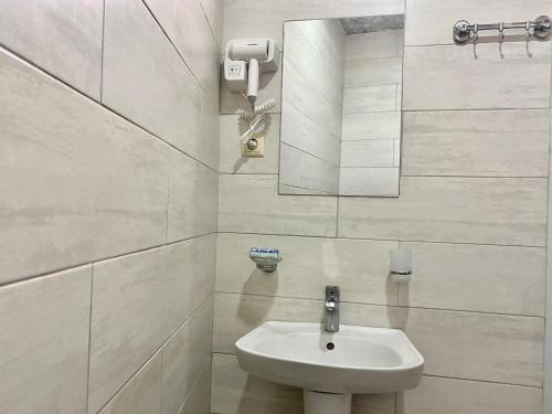 Hotel Charli في كوبوليتي: حمام أبيض مع حوض ومرآة