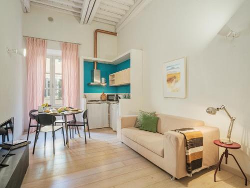 ein Wohnzimmer mit einem Sofa und einem Tisch in der Unterkunft Residenza degli Artisti Apartments in Lucca