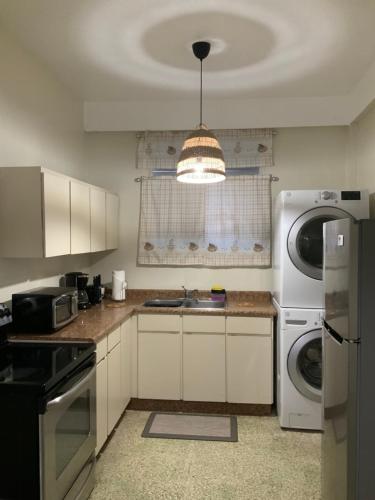 uma cozinha com um lavatório e uma máquina de lavar e secar roupa em Boricua Guest House Apartment em Yauco