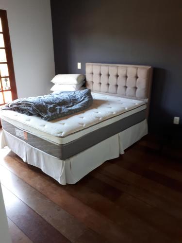 a bed in a bedroom with a white mattress at Terapias integrativas do Sandrin in Jundiaí