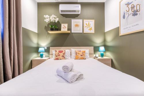a bedroom with a large white bed with towels at Modern Paceville Suites with WIFI & AC by 360 Estates in Paceville