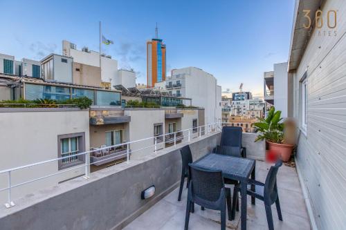 a balcony with chairs and a table on a building at Modern Paceville Suites with WIFI & AC by 360 Estates in Paceville