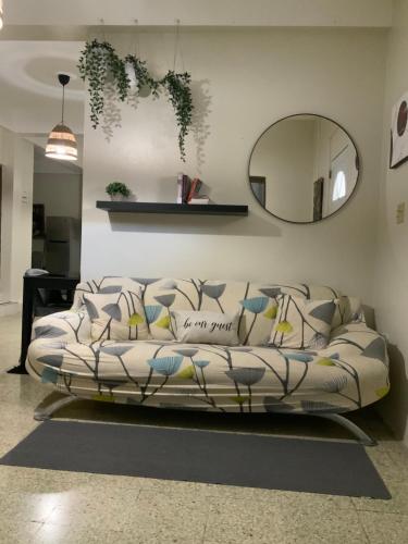 un sofá en una sala de estar con espejo en Boricua Guest House Apartment en Yauco