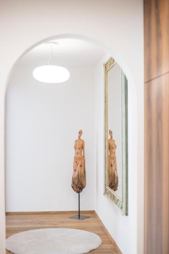 a room with a mirror and a mannequin in front of a wall at Cësa Marmolada 1318 in Ortisei