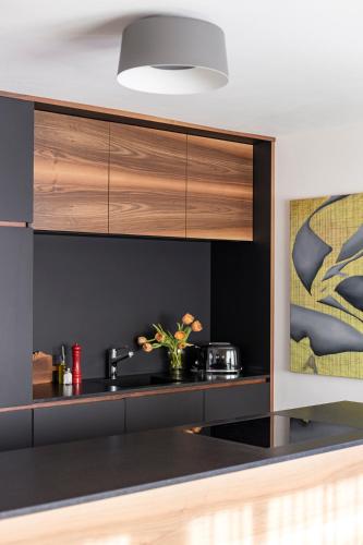 a kitchen with black walls and wooden cabinets at Cësa Marmolada 1318 in Ortisei