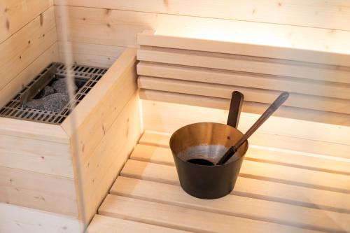 a small wooden sauna with a bucket in it at Cësa Marmolada 1318 in Ortisei