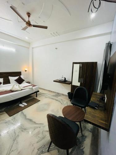 a bedroom with a bed and a desk and chairs at Hotel Sangam View in Prayagraj