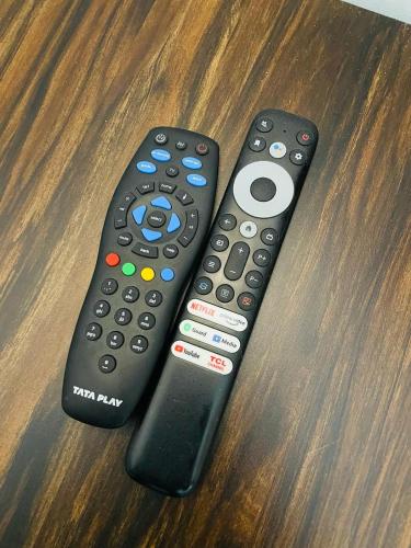 two remote controls sitting on top of a table at Hotel Sangam View in Prayagraj