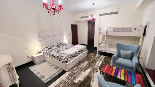 sypialnia z łóżkiem, krzesłem i żyrandolem w obiekcie Nirvana Home w Dubaju