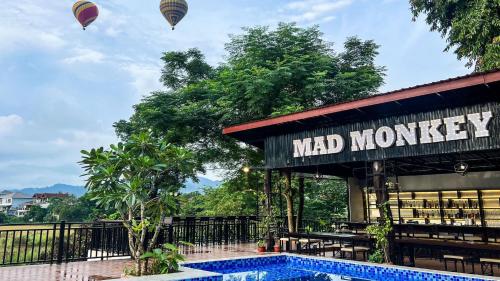 a hotel with two hot air balloons flying over a pool at Mad Monkey Vang Vieng in Vang Vieng