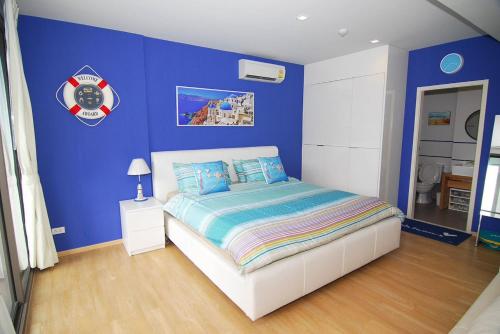 a bedroom with a blue wall with a bed at Baan Sankraam by Baan Captainreua Sankraam in Cha Am