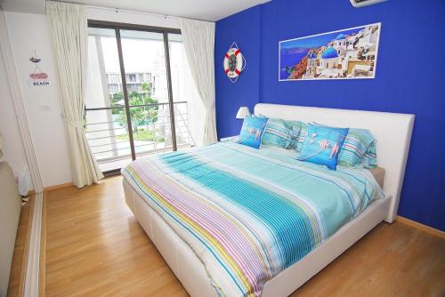 a blue bedroom with a bed with blue walls at Baan Sankraam by Baan Captainreua Sankraam in Cha Am