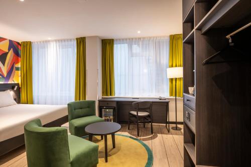 a hotel room with a bed and a desk and chairs at Thon Hotel Rotterdam City Centre in Rotterdam