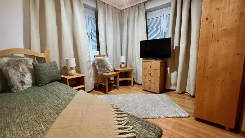 een slaapkamer met een bed en een flatscreen-tv bij Naposdomb Vendégház in Miskolc