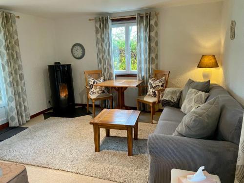 un salon avec un canapé et une table dans l'établissement Labarthe Gites Pigeonnier, à Saint-Aubin-de-Cadelech