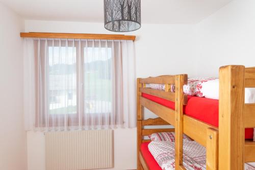 a bedroom with two bunk beds and a window at Pic-Chaussy B14 in Les Mosses