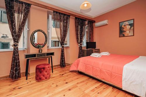 een slaapkamer met een bed, een bureau en een spiegel bij Venetian Reale Apartment in Corfu-stad