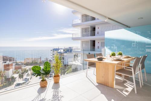 a balcony with a table and chairs and a view of the ocean at Higuerón Rental Med Sunset in Fuengirola