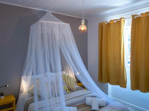 un dormitorio con una cama con mosquitera en House beach in Lizandro by Ericeira Property, en Carvoeira