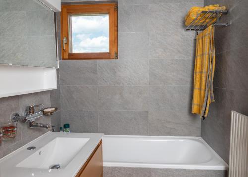 ein Badezimmer mit einer weißen Badewanne und einem Waschbecken in der Unterkunft Pic-Chaussy B14 in Les Mosses