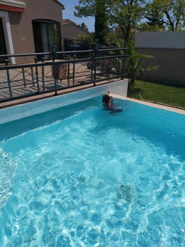 une personne nageant dans une grande piscine dans l'établissement Bel abris, à La Valette-du-Var