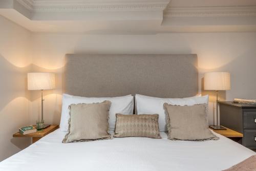 a bedroom with a white bed with two pillows at Spacious, Calm One Bedroom in London