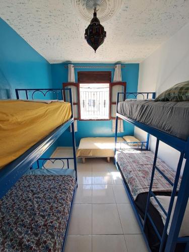 a room with three bunk beds and a window at Moroccan Family House in Agadir