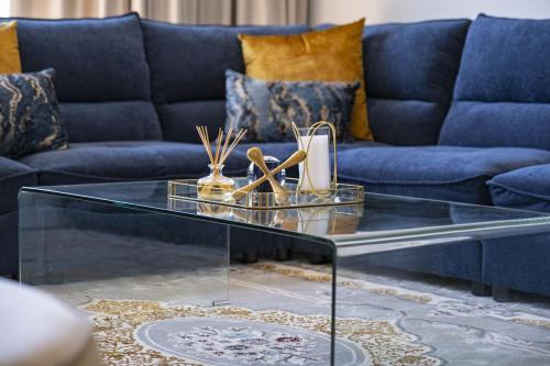 sala de estar con sofá azul y mesa de centro de cristal en Villa Balmoral 14 by HostAgents, en Ciudad del Cabo
