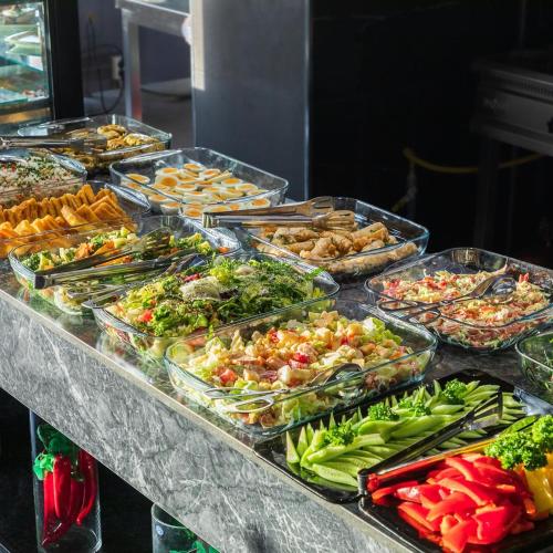 a buffet with many trays of food on a table at HUSMA Hotel & Spa in Tashkent