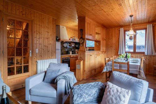 un salon avec une table et des chaises et une cuisine dans l'établissement Serre Chevalier Chantemerle grand appartement 150 m2 dans chalet familial, à Saint-Chaffrey